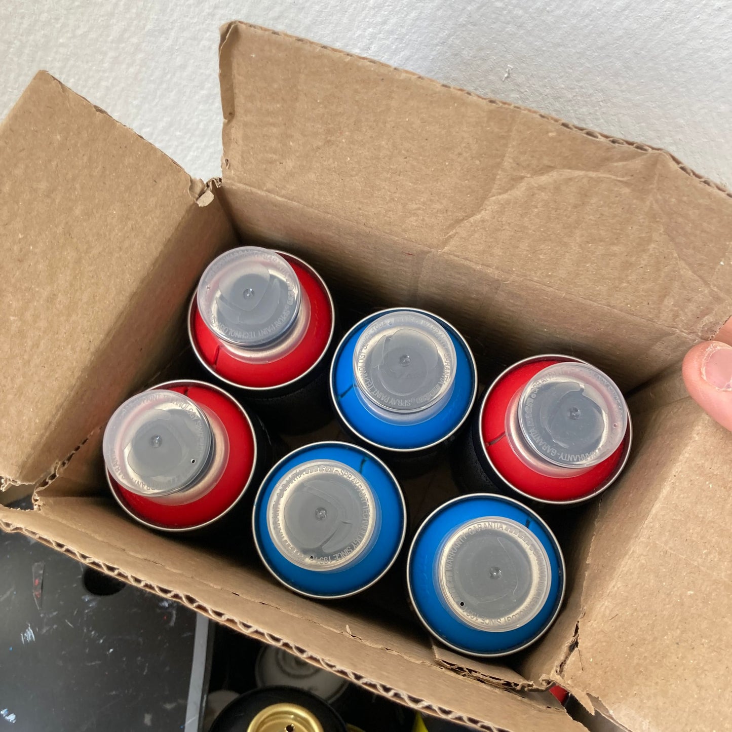 Carton avec des spray pockets bombe de peinture aérosol pour graffiti bleu et rouge