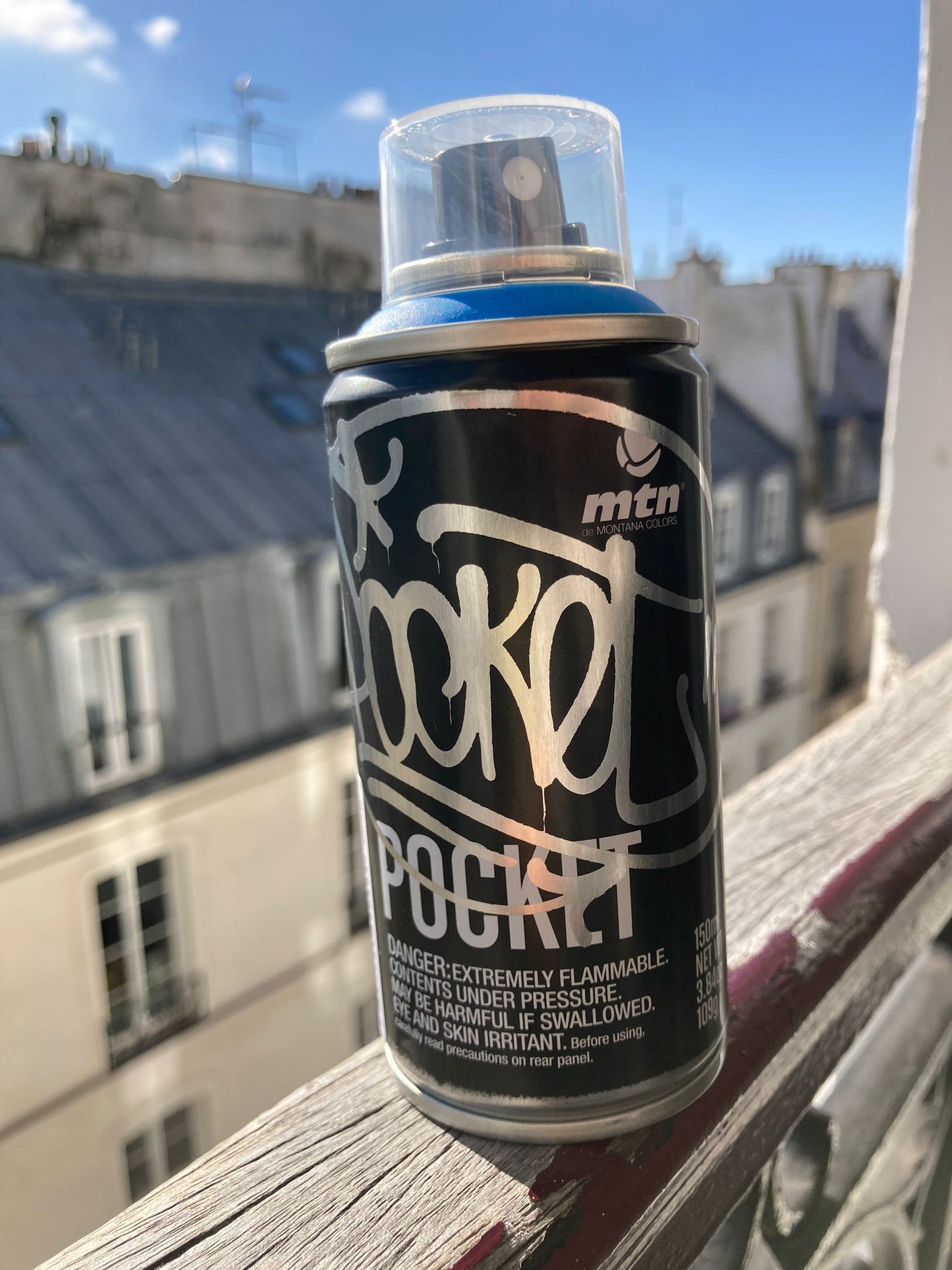 Spray pocket bombe de peinture aérosol pour graffiti bleu vers un toit parisien
